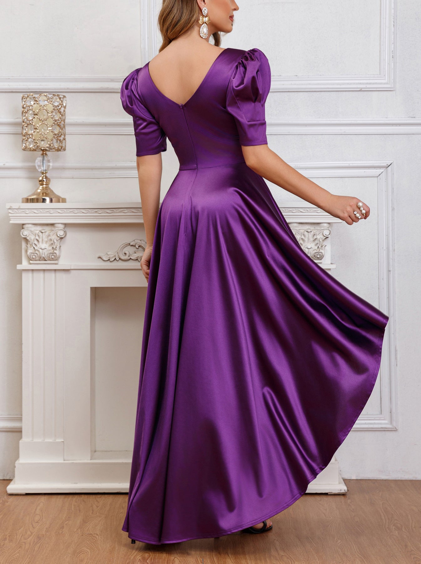 Back view of a purple puff sleeve satin pleated dress featuring a backless V-cut design and elegant draping.