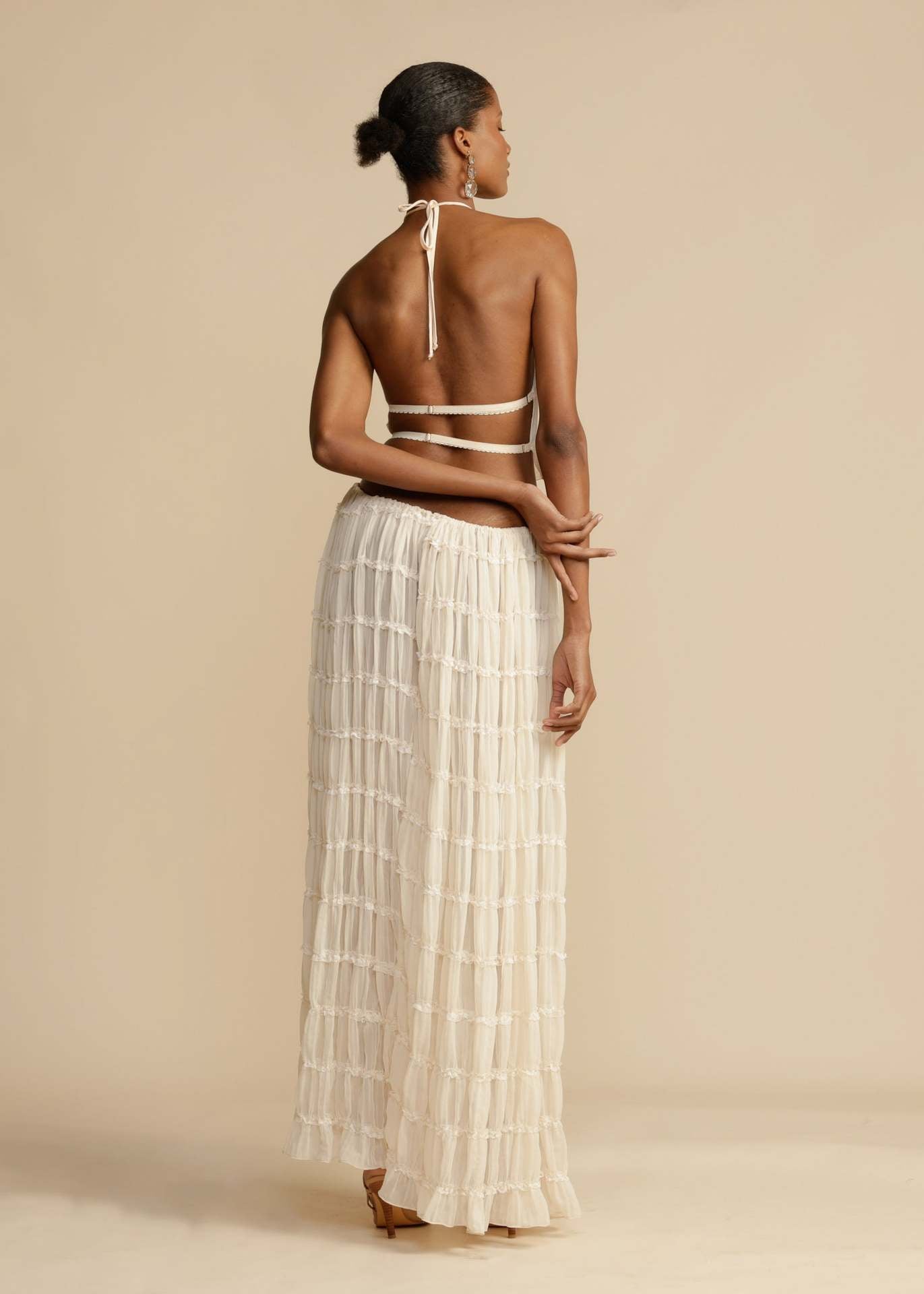 Back view of the White Chiffon Backless Lace-up Pleated Maxi Dress, featuring the adjustable lace-up design and open back.