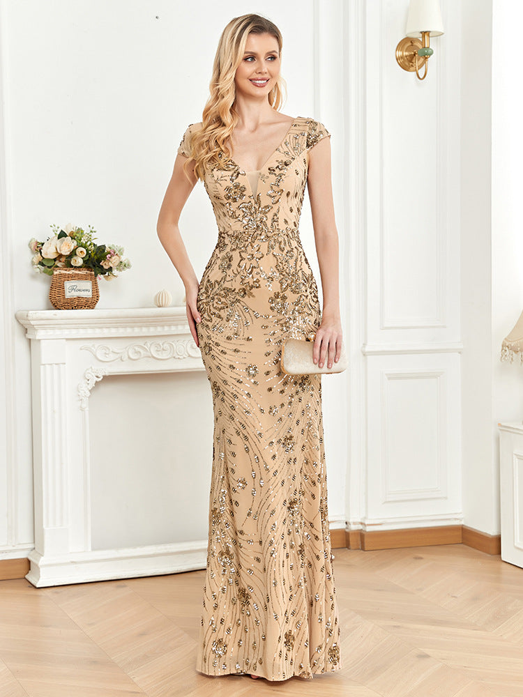 Front view of an elegant champagne mermaid dress featuring a V-neck, sleeveless design, and sparkling sequin embellishments.